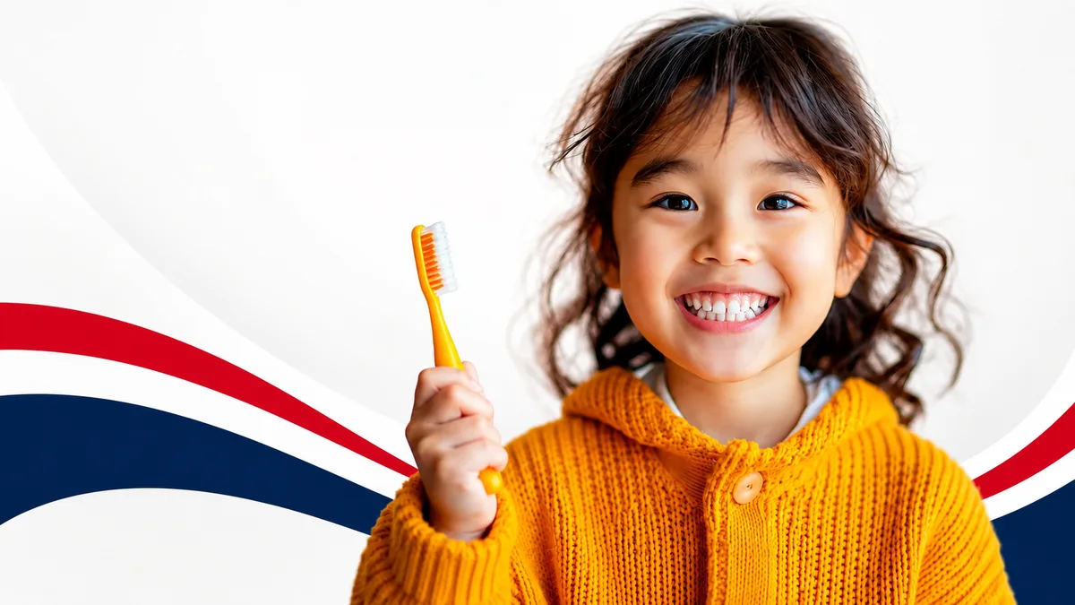A smiling child holding a toothbrush at Dental Group of Mentor