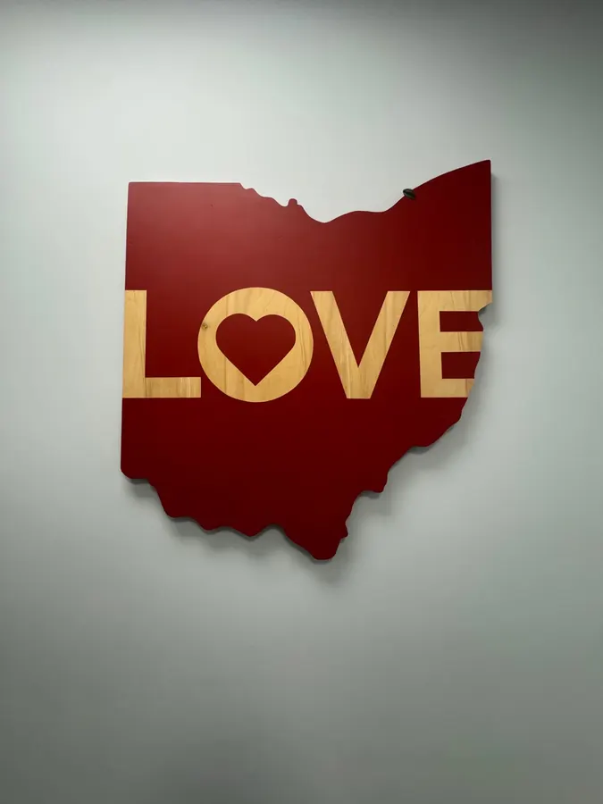 A wooden Ohio cutout reading LOVE on the office wall