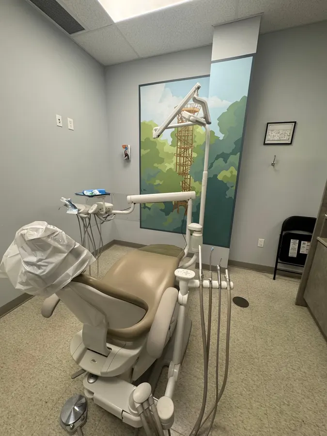 A treatment room with a hand-painted mural of a lookout tower over the treetops