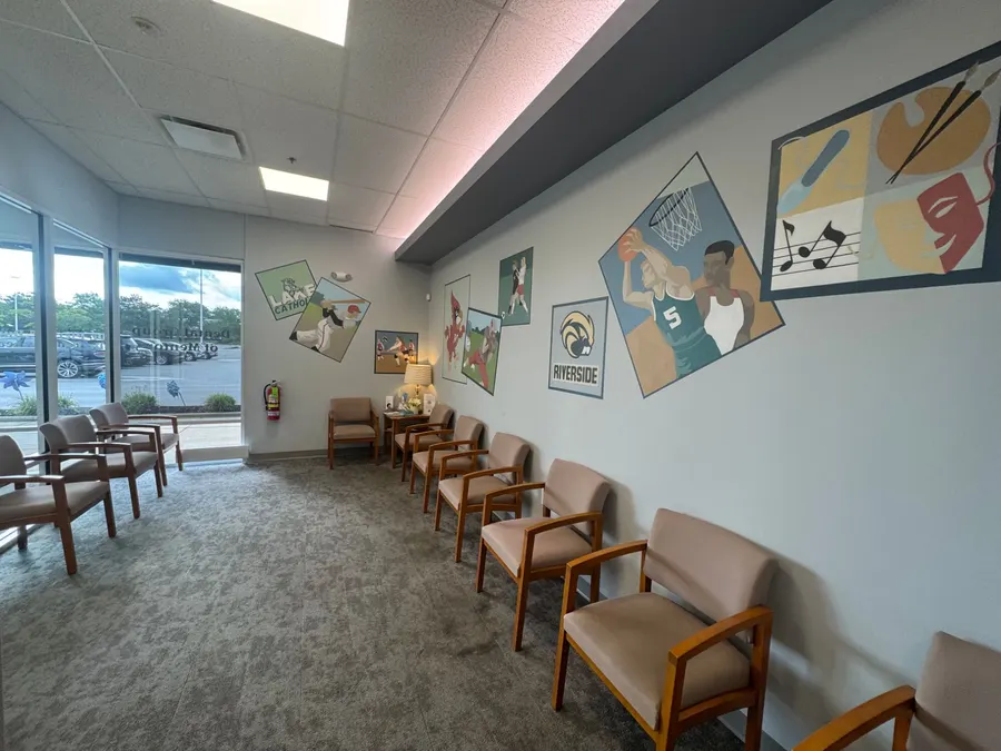 The waiting room, with murals of local school teams along the wall